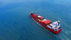 Containerschip vaart over open zee onder toezicht van kapitein en stuurman – verschil tussen stuurman en kapitein