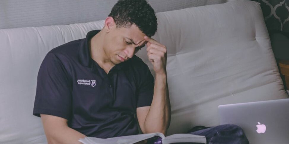 man leest denkend op bank Man kijkt geconcentreerd in een boek terwijl hij op een bank zit, denkend over objectief en subjectief denken
