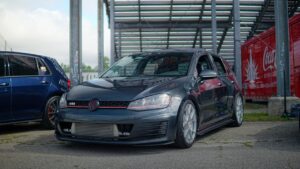 Volkswagen Golf GTI met sportieve velgen geparkeerd op een tuningevent