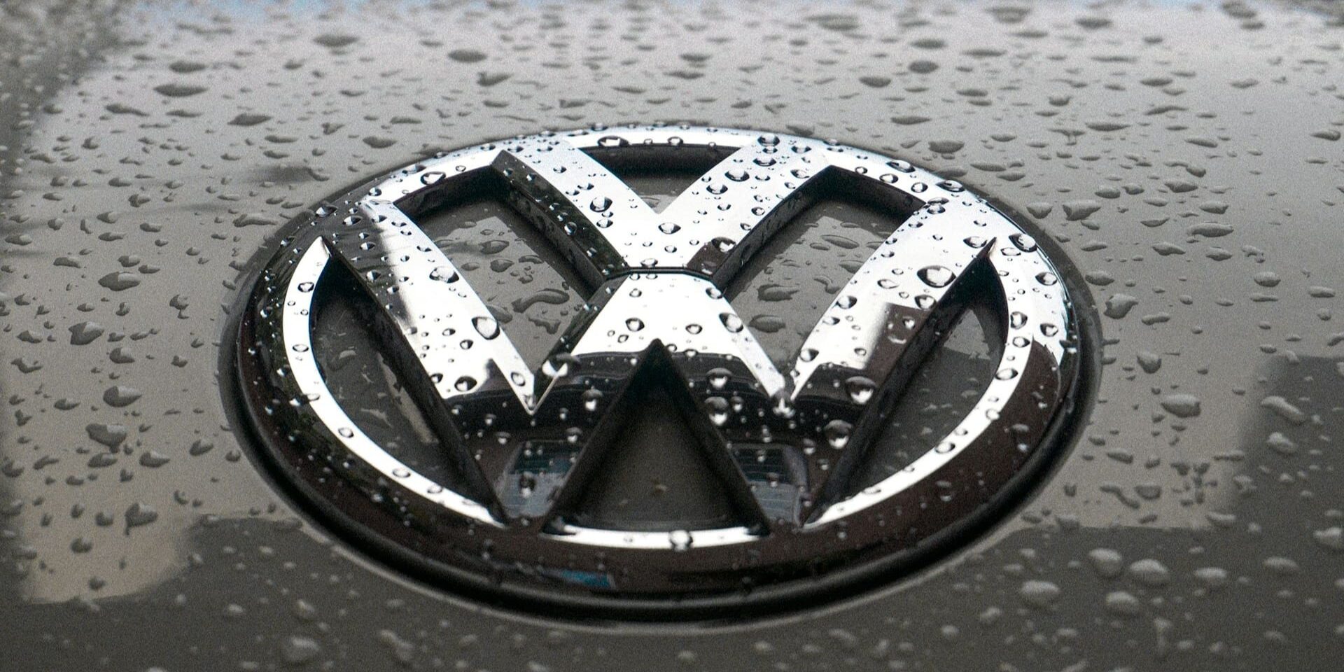 Volkswagen-logo met regendruppels op een motorkap, symbool voor Polo of Golf