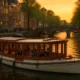 Luxe salonboot vaart door Amsterdamse grachten bij zonsondergang