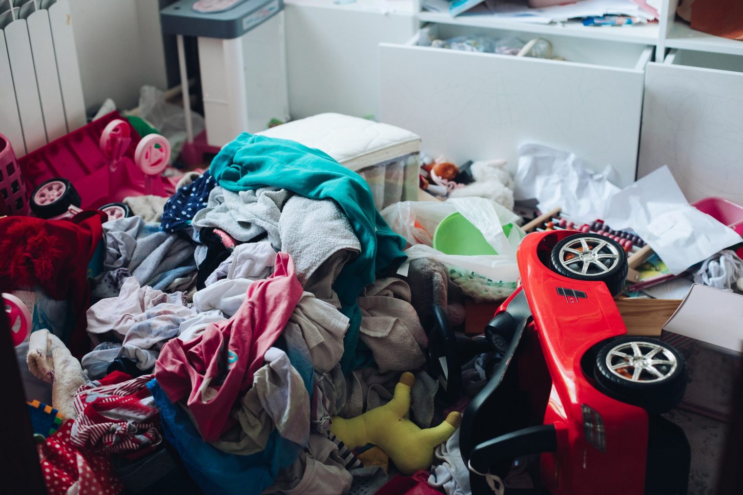 Het verschil tussen een reguliere en een spoedontruiming rommelige ruimte met kleding en speelgoep