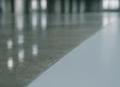 Glanzende gecoate bedrijfsvloer met epoxy-coating naast gepolijst beton