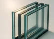 Drie HR++ glas drievoudig glas platen gestapeld met isolatielagen en argonvulling, zonlicht erdoor.